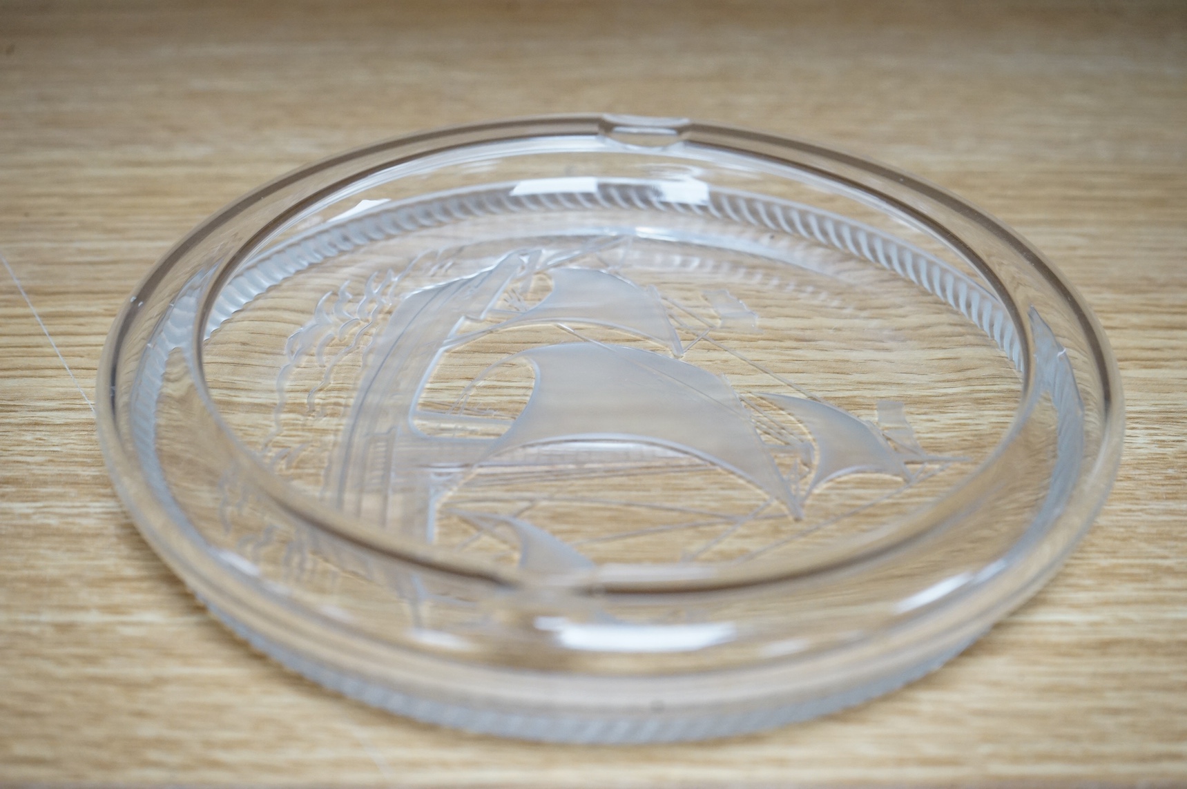 A modern Lalique ashtray decorated with a ship, signed to the base, 17cm in diameter. Condition - good